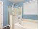 The bathroom features a shower, bathtub, and a window providing natural light at 19863 N Emmerson Dr, Maricopa, AZ 85138