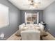 Bright dining room with a large table, comfortable seating, and a view to the yard at 19863 N Emmerson Dr, Maricopa, AZ 85138