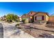 Charming single-story home featuring low-maintenance landscaping, tan stucco, and a tile roof on a sunny day at 19863 N Emmerson Dr, Maricopa, AZ 85138