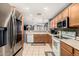 Well-equipped kitchen with wooden cabinetry, stainless steel appliances, and a breakfast bar at 19863 N Emmerson Dr, Maricopa, AZ 85138