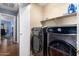 Modern laundry room with front loading washer and dryer and plenty of storage at 19863 N Emmerson Dr, Maricopa, AZ 85138