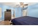 The primary bedroom features blue walls, a ceiling fan, and an ensuite bathroom at 19863 N Emmerson Dr, Maricopa, AZ 85138