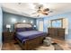 Spacious main bedroom with plush king bed, ceiling fan, and a private ensuite bathroom at 19863 N Emmerson Dr, Maricopa, AZ 85138