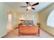 Bedroom with a wooden sleigh bed, arched windows, and a ceiling fan, offering a comfortable retreat at 20930 W Sunriise Ln, Buckeye, AZ 85396