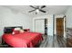 Bedroom with a ceiling fan, wood-look vinyl floors, and a red comforter set at 2107 E Inca St, Mesa, AZ 85213