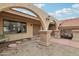 Arched entrance with security gate, desert landscaping, and a view into the home's living room at 2107 E Inca St, Mesa, AZ 85213