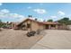Tan single-story home with a red tile roof, desert landscaping, and a concrete driveway on a sunny day at 2107 E Inca St, Mesa, AZ 85213
