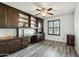 Home office with built-in wood cabinets, desk space, and wood-look vinyl flooring at 2107 E Inca St, Mesa, AZ 85213