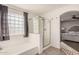 Relaxing bathroom features a glass-enclosed shower, soaking tub, and view into the main bedroom at 22157 W Moonlight Path, Buckeye, AZ 85326