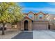 Inviting front exterior of a two-story home with a stone archway and lush landscaping at 22157 W Moonlight Path, Buckeye, AZ 85326