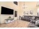 Bright living room featuring a large television, a gray sofa, and a decorative chandelier at 22157 W Moonlight Path, Buckeye, AZ 85326
