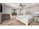 Comfortable main bedroom features soft lighting, a ceiling fan, and a well-lit window at 22157 W Moonlight Path, Buckeye, AZ 85326