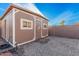 Charming backyard shed providing extra storage with decorative touches including brick trim and a sunflower accent at 22157 W Moonlight Path, Buckeye, AZ 85326