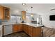 Open kitchen featuring white countertops, wooden cabinets, modern backsplash, and views into a spacious living area at 2230 W Peralta Ave, Mesa, AZ 85202