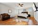 Comfortable main bedroom featuring hardwood floors, ceiling fan, and a large bed at 22472 N 80Th Ln, Peoria, AZ 85383