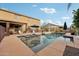 Backyard view of a sparkling swimming pool with a spa, lounge chairs, and well-manicured landscaping at 22472 N 80Th Ln, Peoria, AZ 85383