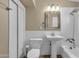 Clean bathroom features a pedestal sink, white subway tile and updated lighting fixture above the mirror at 2545 E Amelia Ave, Phoenix, AZ 85016