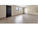 Bright living room with neutral walls, wood-look tile flooring, and a large window at 2545 E Amelia Ave, Phoenix, AZ 85016