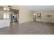 Spacious living room with neutral walls, wood-look tile flooring, utility bar and stainless appliances at 2545 E Amelia Ave, Phoenix, AZ 85016