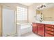 Bright bathroom featuring a separate tub and shower, and warm wood vanity at 2621 E Stottler Dr, Gilbert, AZ 85296