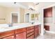 Bathroom with a dual sink vanity, large mirrors, and neutral tile flooring at 2621 E Stottler Dr, Gilbert, AZ 85296