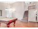 Spacious living room with hardwood floors, a pool table, and a staircase leading to the upper level at 2621 E Stottler Dr, Gilbert, AZ 85296