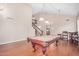 Open living space with a pool table, hardwood floors, and staircase with wood railing and neutral walls at 2621 E Stottler Dr, Gilbert, AZ 85296