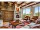 Cozy living room with fireplace, wood beamed ceiling, stone accent wall at 27903 N Agua Verde Dr, Rio Verde, AZ 85263