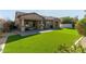 A spacious backyard offers a covered patio and manicured lawn at 3344 E Grand Canyon Dr, Chandler, AZ 85249