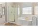 Bathroom features glass enclosed shower, a bathtub, and a window with natural light at 3344 E Grand Canyon Dr, Chandler, AZ 85249
