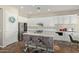 Well-lit kitchen with a breakfast bar island with modern white cabinets, and stainless steel appliances at 3344 E Grand Canyon Dr, Chandler, AZ 85249