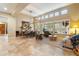 Open-concept living room with high ceilings, travertine floors, large windows, and stylish furnishings at 33705 N 64Th St, Scottsdale, AZ 85266