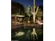 The pool area is the focal point, surrounded by desert landscaping and night lighting that creates a relaxing outdoor space at 33705 N 64Th St, Scottsdale, AZ 85266