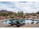 Relax by the pool with desert views, a rock waterfall, and comfortable lounge chairs at 35045 N 52Nd Pl, Cave Creek, AZ 85331