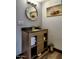 Bathroom vanity with a granite countertop, storage shelves, and a round mirror at 461 W Holmes Ave # 308, Mesa, AZ 85210