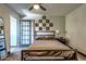 Comfortable bedroom featuring a queen bed, minimalist decor, and a glass paneled door at 461 W Holmes Ave # 308, Mesa, AZ 85210
