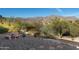 Serene backyard featuring a stone table, desert landscaping, and breathtaking mountain vistas at 4845 S Strike-It-Rich Dr, Gold Canyon, AZ 85118