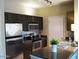 Compact kitchen equipped with stainless steel appliances, dark cabinetry, and a granite countertop at 5345 E Van Buren St # 111, Phoenix, AZ 85008