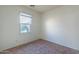 Simple, carpeted bedroom featuring neutral colors and a window for natural light at 5619 S 21St Pl, Phoenix, AZ 85040