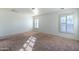 Spacious bedroom with carpet flooring, white walls, and plantation shutters at 5619 S 21St Pl, Phoenix, AZ 85040