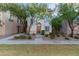 Charming townhome featuring a landscaped front yard with mature trees and a welcoming front entrance at 5619 S 21St Pl, Phoenix, AZ 85040