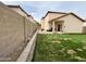 Spacious backyard with a manicured lawn, brick-paved patio, and a private block wall fence at 671 E Colt Ct, Chandler, AZ 85225