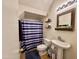 Cozy bathroom with a pedestal sink, tiled floors, and a shower/tub with a blue patterned curtain at 671 E Colt Ct, Chandler, AZ 85225