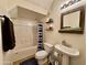 Comfortable bathroom featuring a shower/tub with curtain, pedestal sink, and built-in shelving at 671 E Colt Ct, Chandler, AZ 85225