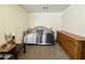 Bedroom with neutral walls, carpet, daybed, dark-colored table with flowers, and wood dresser at 671 E Colt Ct, Chandler, AZ 85225