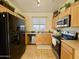 Well-lit kitchen featuring stainless steel appliances, tile floors, and light wood cabinets at 671 E Colt Ct, Chandler, AZ 85225