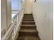 Carpeted staircase with white railing leading to the upper level, bathed in natural light at 671 E Colt Ct, Chandler, AZ 85225