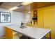 Bright kitchen featuring an island with seating, sleek appliances, and yellow cabinets at 6850 E Main St # 4404, Scottsdale, AZ 85251