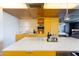 Modern kitchen featuring an island with seating, sleek appliances, and bright yellow cabinetry at 6850 E Main St # 4404, Scottsdale, AZ 85251