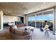 Bright living area featuring concrete ceilings, a modern sofa and sliding glass doors to a patio with city views at 6850 E Main St # 4404, Scottsdale, AZ 85251